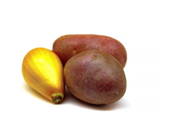 Shallots and two potato tubers close up isolated on a white background