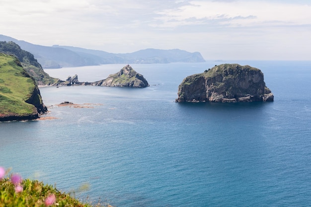 Shallow bay with two small islands Gaztelugatxe and Aketx Basque country Cape Matxitxako Bermeo