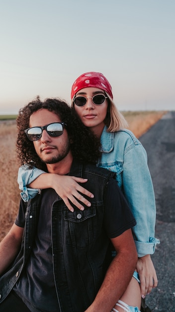 Shallow focus of a cool young couple posing on a motorcycle on the road