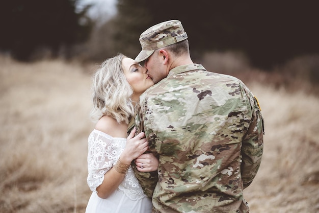 Shallow focus shot of an American soldier kissing his loving wife on the field