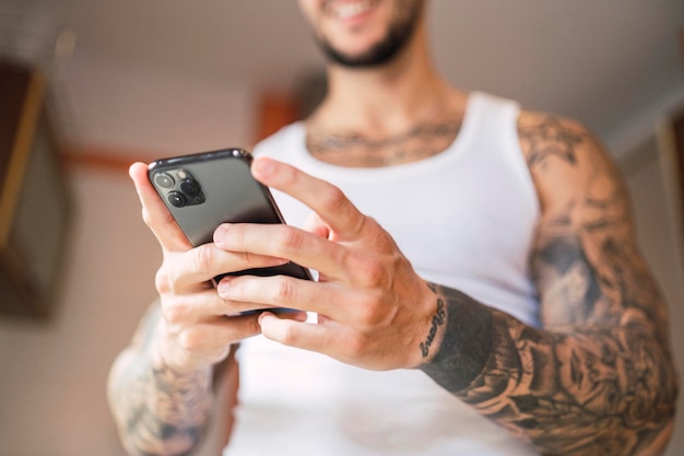 Shallow focus shot of a Caucasian fit male using his smartphone