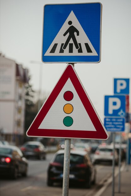 Shallow focus shot of a crossing and traffic light signs during daytime