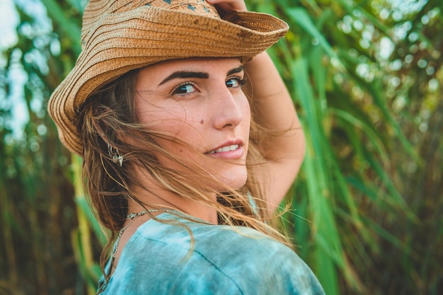 Shallow focus shot of a European female with a cowboy hat on the beach