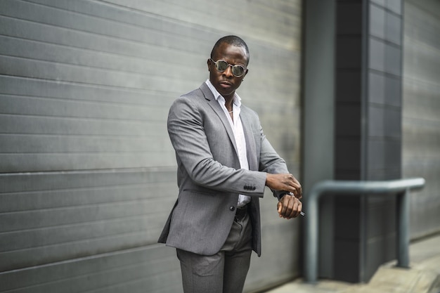 スーツとサングラスをかけたハンサムな自信のあるアフリカ人男性の浅いフォーカスショット