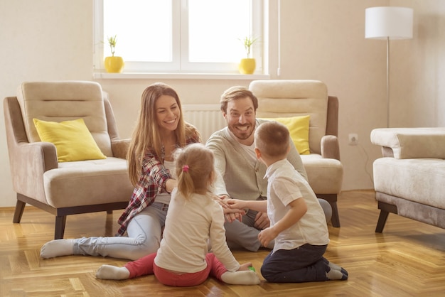 Colpo poco profondo del fuoco di una famiglia caucasica felice che ha divertimento che gioca un gioco