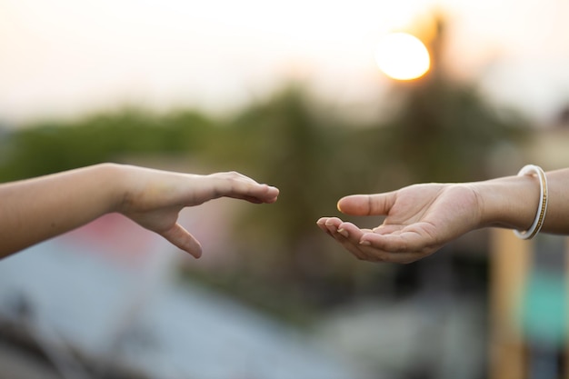 写真 互いに手を伸ばしている2人の手の浅い焦点ショット