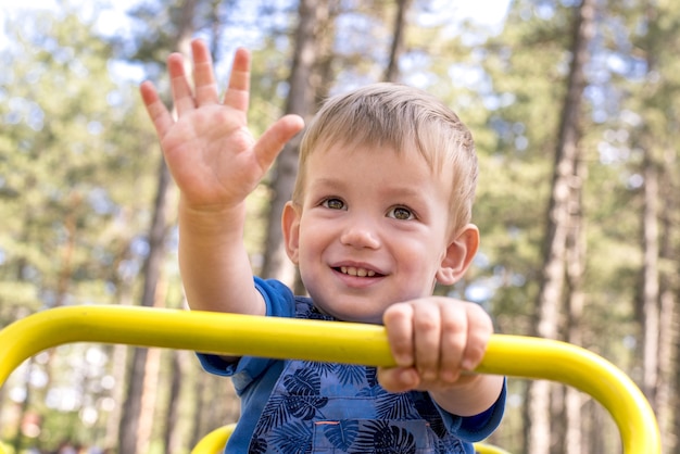 Inquadratura poco profonda di un bambino sorridente che si diverte nel parco giochi