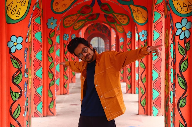 Photo shallow focus shot of a south asian model posing in front of a madhubani painting