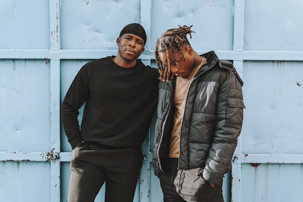 Shallow focus of two Black men in casual clothing standing outside a building