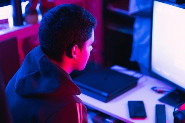 Shallow focus of a young Hispanic male gamer streaming a video game online