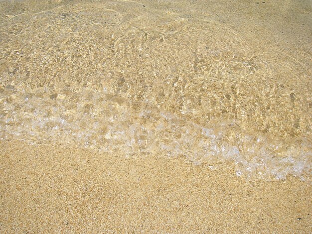 Foto sabbia poco profonda con onde d'acqua cristallina