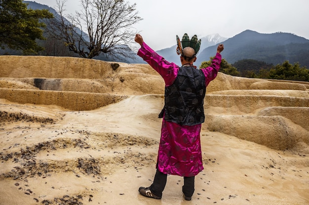 Shaman in national clothes making authentic ritual of summoning spirits in Baishutai China