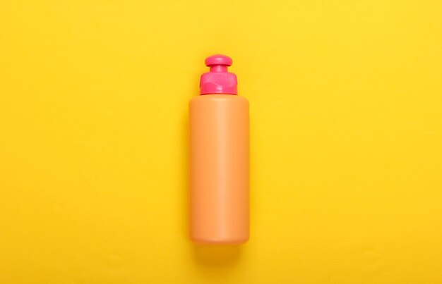 Shampoo bottle on yellow. Hair care. Hygiene and cosmetics.