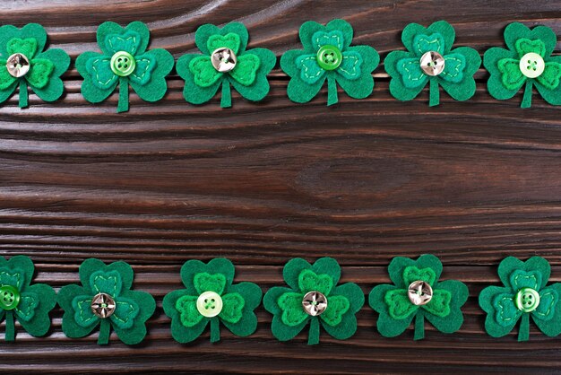 Shamrock leaves on dark wooden background with copyspace flat lay view