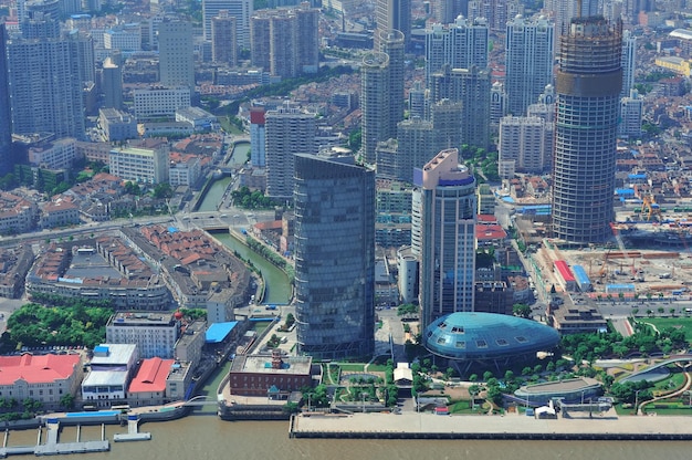 Shanghai city aerial view with urban architecture over river in the day.