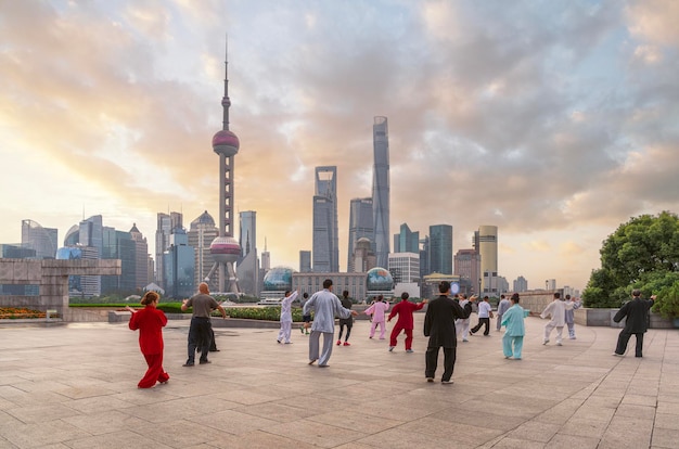 Foto shanghai stad en chinese mensen oefenen met tai chi rivier en ochtend hemel achtergrond shanghai chi