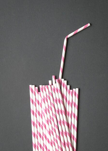 Photo shape of glass with straw made up of paper straws on black background