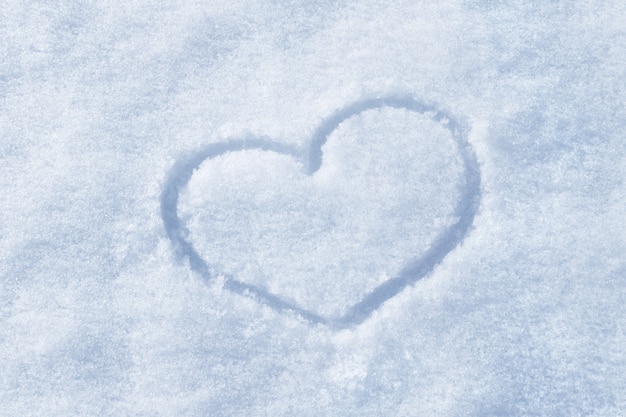 Photo the shape of heart painted on the white snow