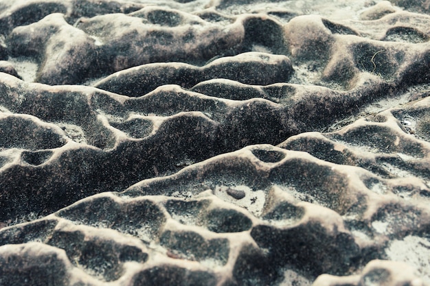 Shape of the rock is caused by the waves of the waterfall, after the water is dry