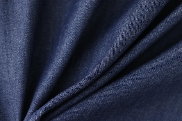 Shaped greyblue textile as background waved blue fabric closeup