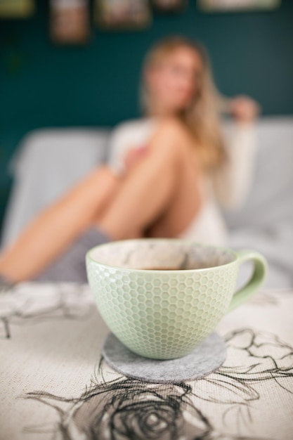 Foto le gambe ben formate di una ragazza sexy una tazza di caffè caldo