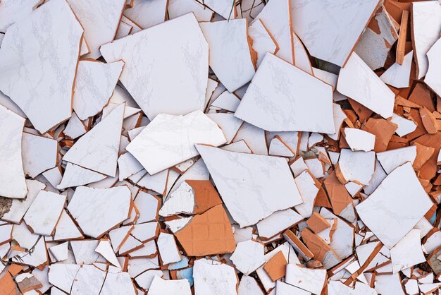 Shards of broken white ceramic tiles background