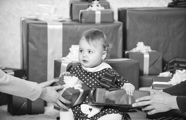 Sharing joy of baby first christmas with family Baby first christmas once in lifetime event Little baby girl play near pile of gift boxes Gifts for child first christmas Celebrate first christmas