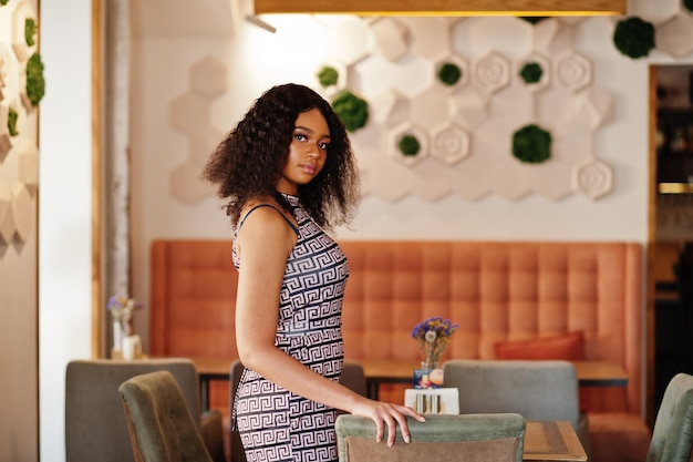 Сheerful african american young woman in summer dress and choker necklace  at cafe drinking milkshake cocktail Stock Photo - Alamy