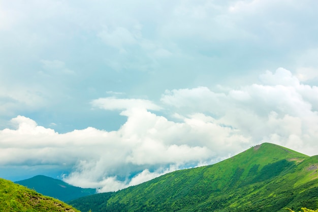 写真 鋭い緑の山の峰と劇的な雲の風景と空