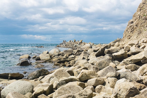 Rocce di basalto frastagliate taglienti sulla costa del mare capo stolbchaty sull'isola di kunashir