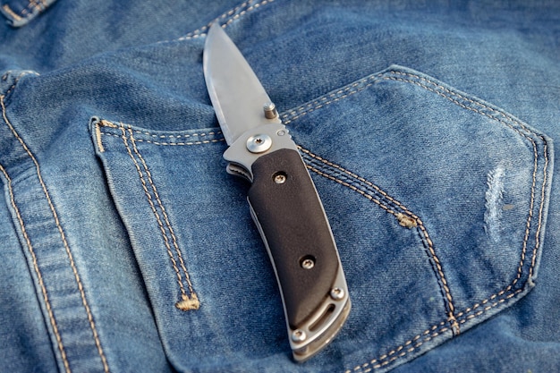 A sharp knife on a jeans background in nature