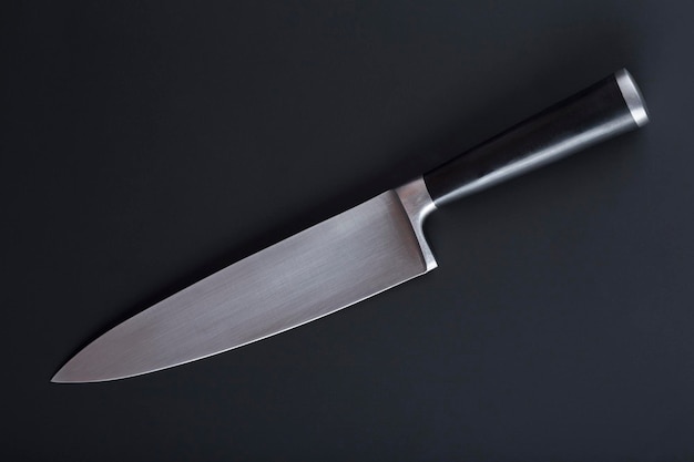 Sharp large kitchen knife on a dark surface