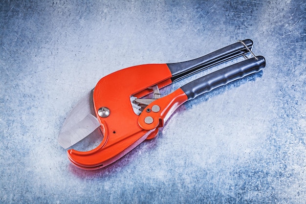 Sharp pipe cutter on metallic background construction concept