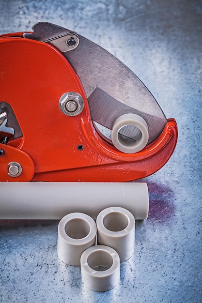 Photo sharp pipe cutter water tubes on scratched metallic background construction concept