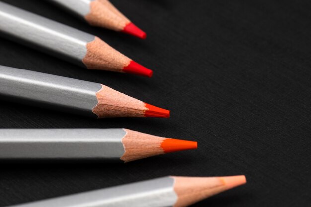 Sharpened colored pencils in a silver shirt on a black paper background