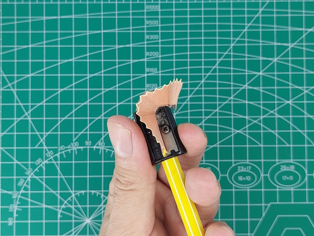鉛筆に削り器をあてる 削り器から削りかすが出てくる