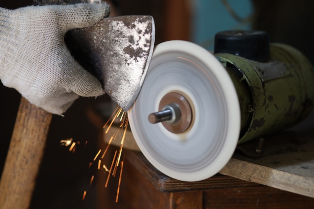 Sharpening an ax on a sharpener close-up