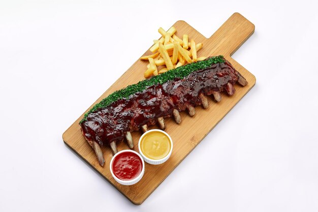 Shashlik or grilled meat ribs with sauce and onion with Fries on wooden board White Background Food Sales Concept Readytouse Menu