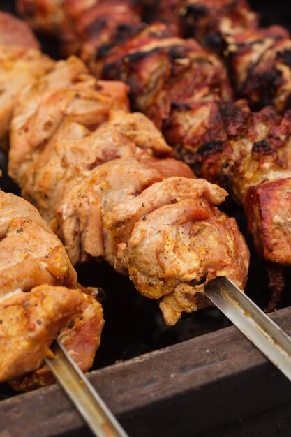 Shashlik on skewers closeup, raw and cooked