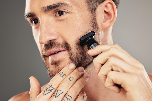 미용 위생 및 피부 관리를 위한 스튜디오에서 면도기 수염 및 남성 미용 건강 면도 및 회색 배경으로 격리된 화장용 면도기로 얼굴 털을 면도하는 건강한 남성