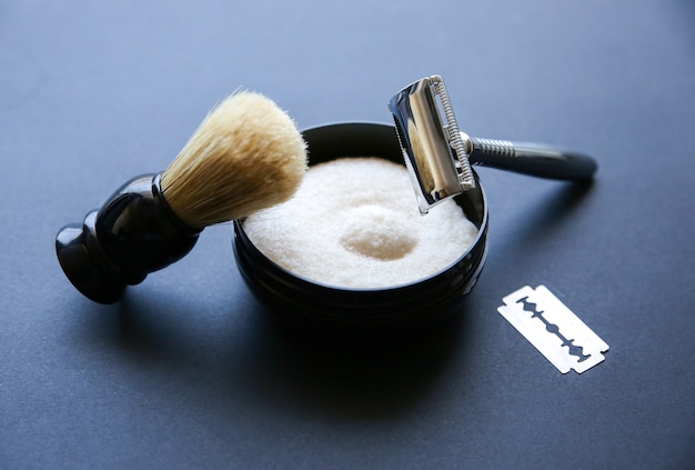 Shaving brush, razor and blade on the table. Stylish men set. idea for a gift. Barber shop things.