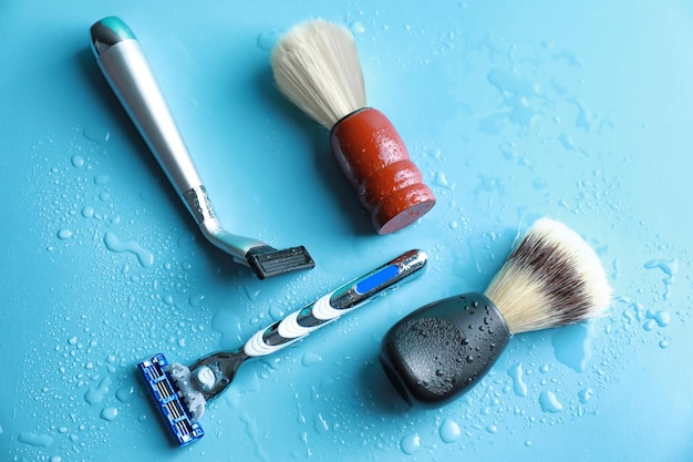 Shaving brushes and razors for man on color background