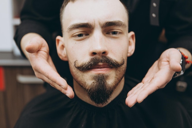 Shaving and modeling a contemporary beard shape in retro style the barber shaves his client