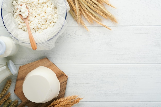 Shavuot jewish holiday celebration Milk and cheese ripe wheat and fruits cream on white wooden background Dairy products over white wooden background Shavuot concept Top view Mock up