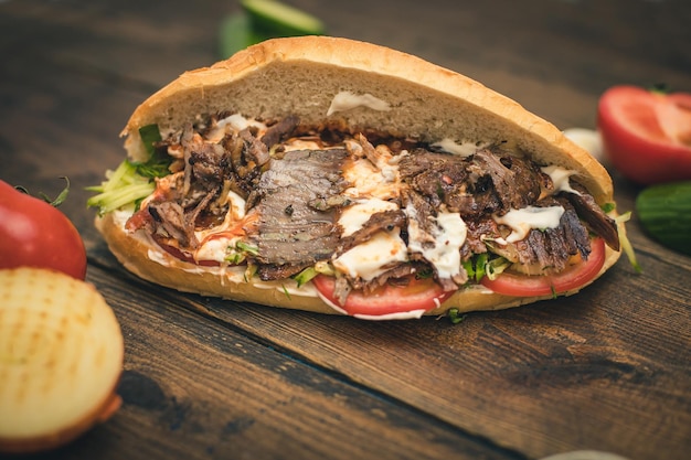 Shawarma or doner with yogurt tomatoes and herbs in a bun