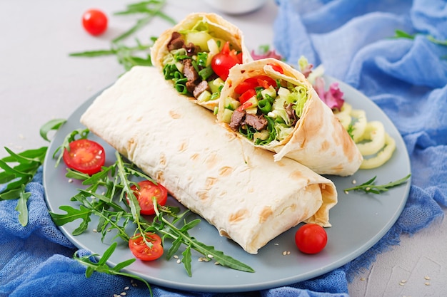 Shawarma from juicy beef, lettuce, tomatoes, cucumbers, paprika and onion in pita bread. 