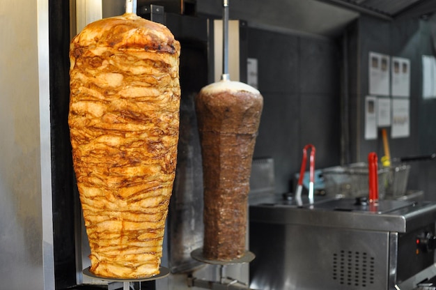 Photo shawarma is being cooked on a rotisserie chicken kebab