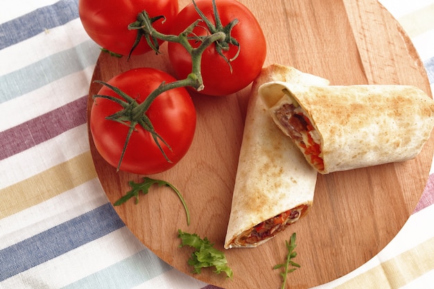 Shawarma in pita and natural organic tomatoes with greens