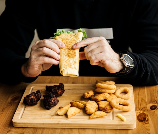 Shawarma sandwich t made of pita bread falafel Traditional Middle Eastern snack in hand on a wooden background recipe