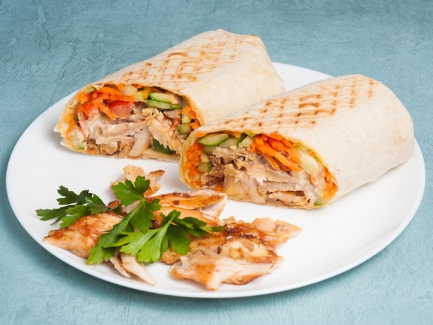 Shawarma with chicken and vegetables on a blue background Closeup